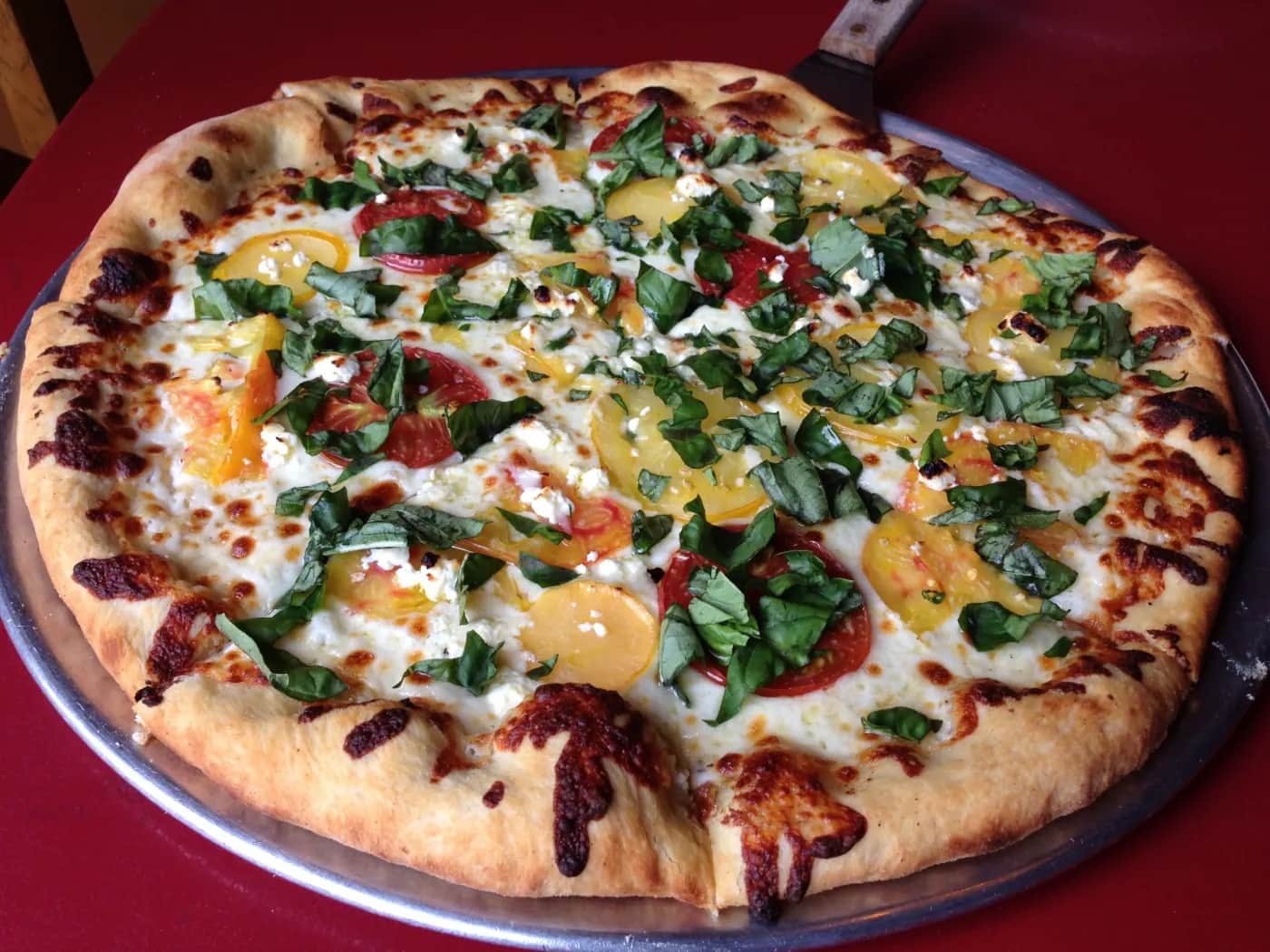 A fresh white pie with heirloom tomatoes and basil